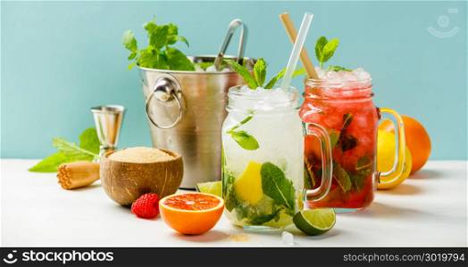 Fresh cocktail drinks with ice fruit and herb decoration. Alcoholic non-alcoholic drink-beverage. Mojito on blue background. Fresh cocktail drinks