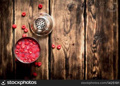fresh cocktail of wild raspberries in a shaker. On a wooden table.. fresh cocktail of wild raspberries in a shaker.