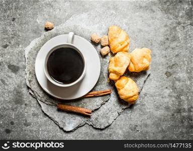 Fresh coffee and croissants. On the stone table.. Fresh coffee and croissants. On stone table.