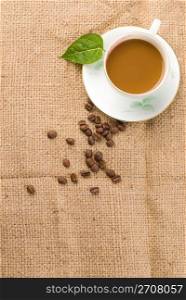 fresh coffee with beans and green leaf on linen background