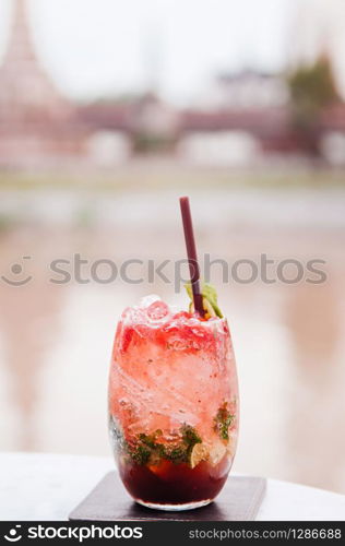 Fresh cold sweet and sour red Mojito cocktail in beautiful glass with lime slices and mint leaves