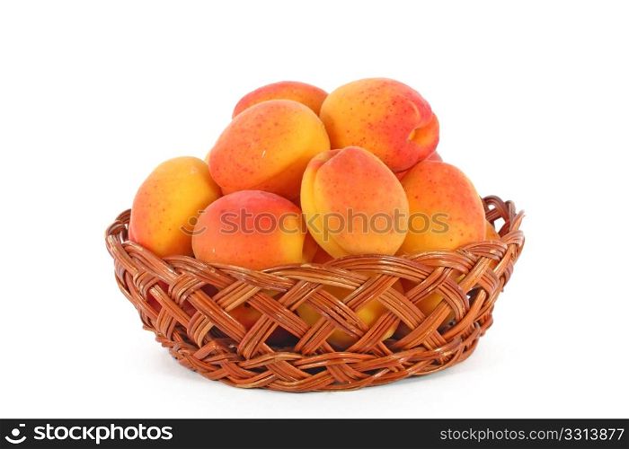 Fresh, colorful ripe apricots in a basket, isolated on white