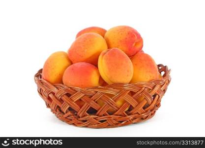 Fresh, colorful ripe apricots in a basket, isolated on white