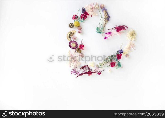 fresh colorful spring flowers in shape of heart isolated on white bright background, flat lay, top view. Spring concept. Pattern romantic heart symbol copy space. fresh colorful spring flowers in shape of heart isolated on white bright background, flat lay, top view. Spring concept. Pattern romantic heart symbol