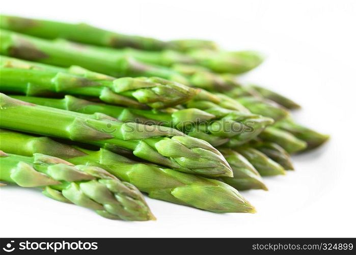 Fresh cooked green asparagus on white plate (Selective Focus, Focus on the asparagus head one third into the image). Cooked Green Asparagus