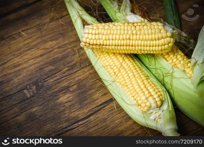 Fresh corn on cobs and sweet corn ears on rustic wooden table background