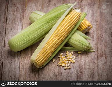 Fresh corn on cobs on rustic wooden table, closeup
