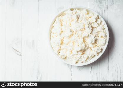 Fresh cottage cheese in bowl on the table. The cottage cheese