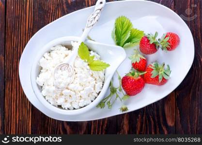 fresh cottage with strawberry on plate and on a table
