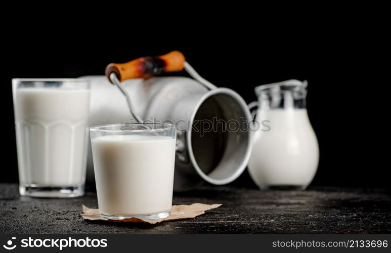 Fresh country milk in a glass on the table. On a black background. High quality photo. Fresh country milk in a glass on the table.