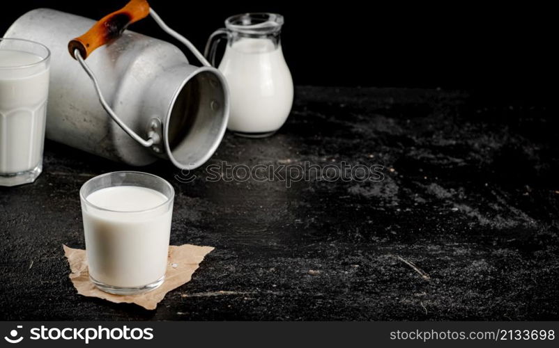 Fresh country milk in a glass on the table. On a black background. High quality photo. Fresh country milk in a glass on the table.