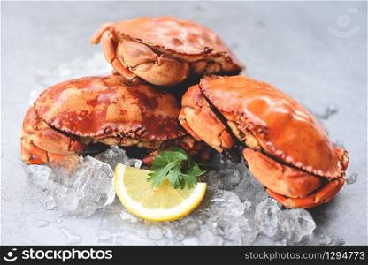 Fresh crab on ice and lemon for salad on plate background / Cooked crabs seafood