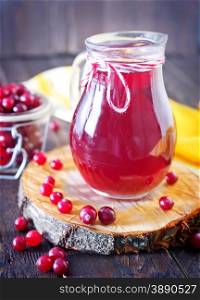 fresh cranberry in bowl and juice in jug on a table