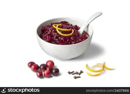 Fresh cranberry sauce with orange and cloves on white background