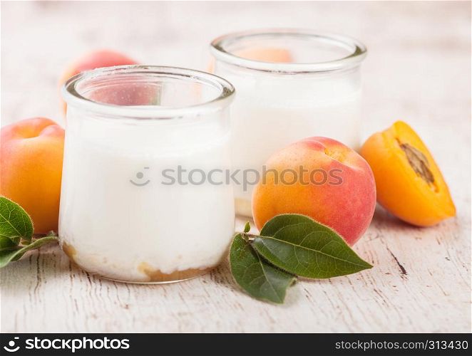Fresh cream dessert with raw organic apricots on wooden board.