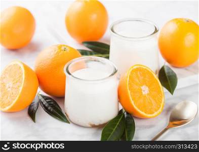 Fresh cream dessert yogurt with raw oranges on wooden board