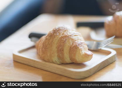 fresh croissant on wood plate