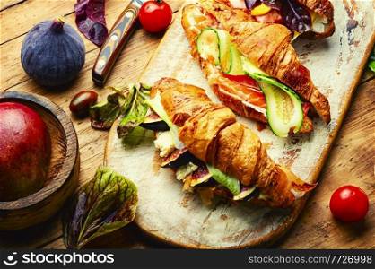 Fresh croissants,healthy breakfast.Croissants with trout, meat bacon, vegetables and fruits. Croissants or sandwich with meat and fish
