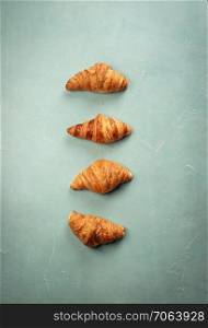 Fresh croissants on rustic concrete background, flat lay