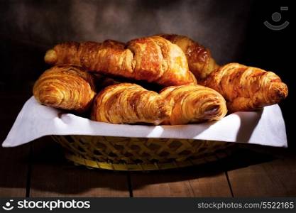 fresh croissants on wooden table