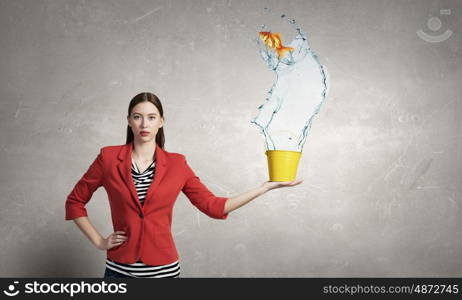 Fresh crystal water. Young woman pouring water from yellow bucket