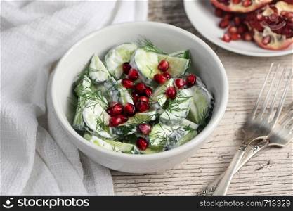 Fresh cucumber salad with dill and pomegranate kernels, in yoghurt sauce