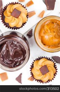 Fresh cupcake muffins with caramel and toffee on marble board