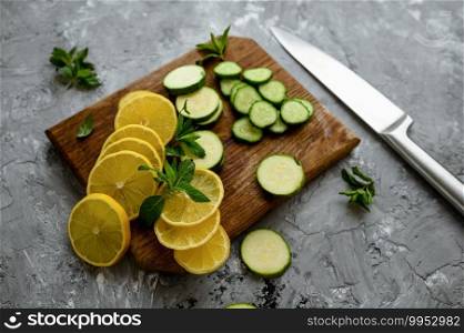 Fresh cutted lemon and cucumber isolated on grunge abstract background. Organic vegetarian food, grocery assortment, natural eco products, healthy lifestyle concept. Cutted lemon and cucumber on grunge background