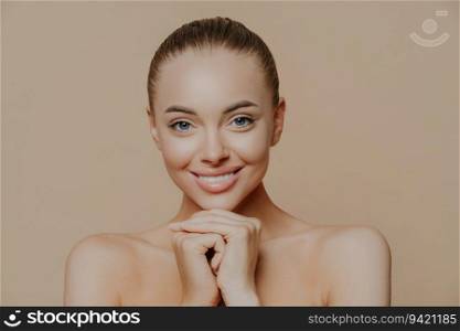 Fresh daily makeup, toothy smile. Hands under chin. Half-naked indoors. Refreshed after cosmetic procedures. Beauty, face care concept.