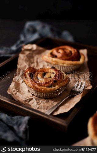 Fresh danish pastry with raisins on wood background.Tasty sweet bakery.