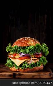 Fresh delicious homemade grilled burger with turkey cutlet with cheese and vegetables on a wooden board, on a dark background. Close up, selective focus with copy space, vertical frame