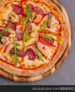 Fresh delicious pizza with three types of meat and sausage