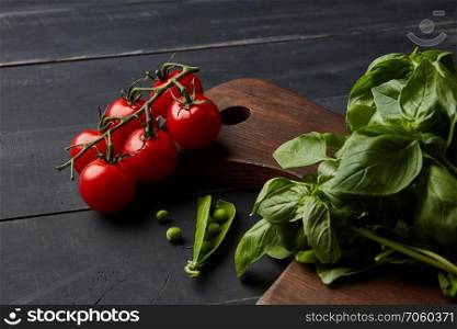 Fresh different raw vegetables and spices on a dark wooden background. Healthy organic food concept.. Fresh vegetables and herbs on a dark wooden background.