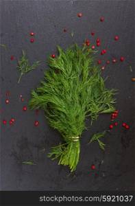 Fresh dill. Fresh green dill with red pepper spice on black board
