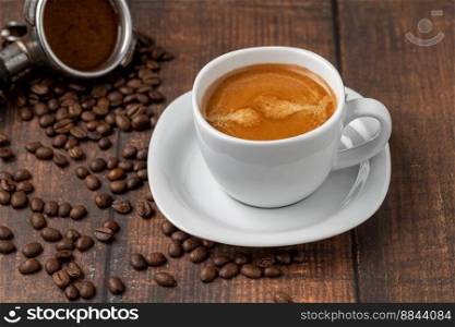 Fresh double espresso coffee and coffee beans on wooden table