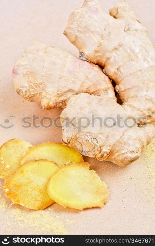 Fresh, dried and powdered ginger at brown background