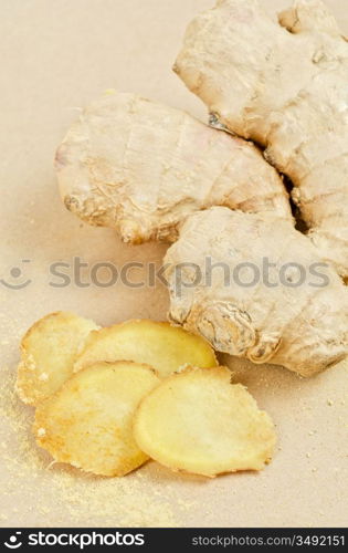 Fresh, dried and powdered ginger at brown background