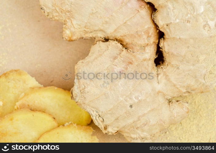 Fresh, dried and powdered ginger at brown background