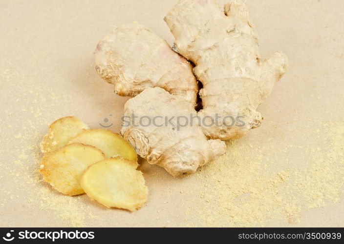 Fresh, dried and powdered ginger at brown background