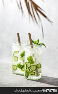 Fresh drinks with cucumber and mint, cold summer lemonade. Modern minimalism concept. Sunny day shadows