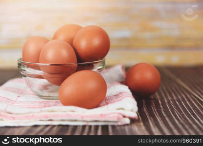 Fresh egg bowl on tablecloth on the wooden table background / Raw chicken eggs collect from the farm products natural eggs for food