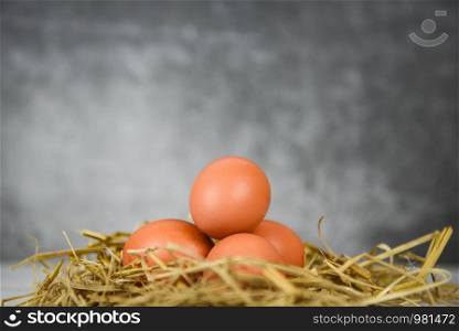 Fresh egg on straw with wooden table background / Raw chicken eggs collect from the farm products natural eggs