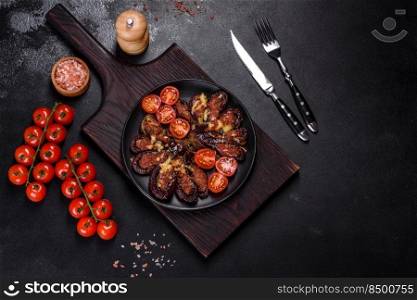 Fresh eggplant baked with minced meat, spices and herbs on a black plate against a dark concrete background. Fresh eggplant baked with minced meat, spices and herbs on a black plate
