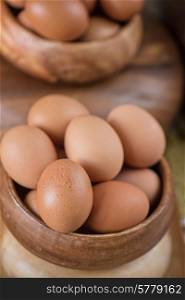 Fresh eggs at wooden plate closeup. Fresh eggs