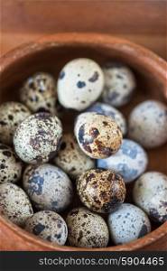 Fresh eggs . Fresh chicken eggs and quail eggs at wooden plate closeup