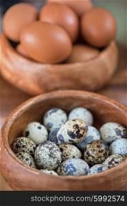 Fresh eggs photo. Fresh chicken eggs and quail eggs at wooden plate closeup