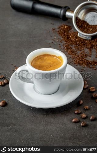 Fresh espresso coffee with coffee beans on dark background