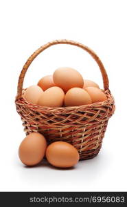 Fresh farm eggs in wicker basket isolated on white background. Concept of healthy organic food