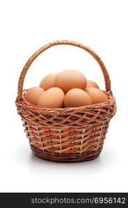 Fresh farm eggs in wicker basket isolated on white background. Concept of healthy organic food