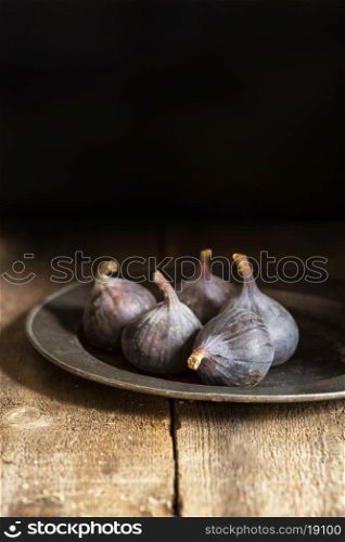 Fresh figs in moody natural lighting set with vintage style
